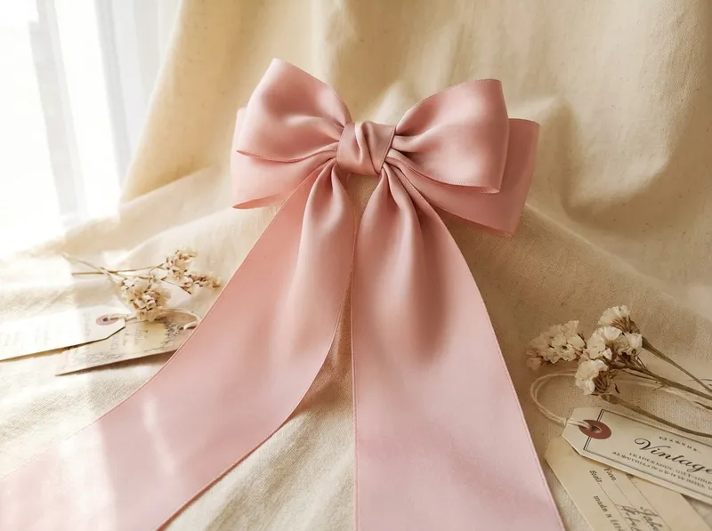 A large hand-tied blush satin bow